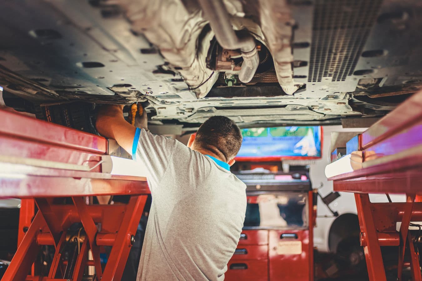 Reparador aplicando um processo seguro em um veículo elevado